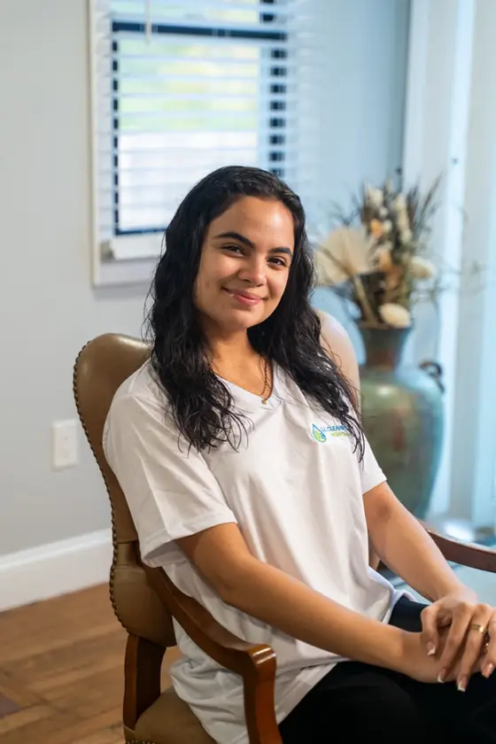 LL Cleaning team member seated in a leather chair, smiling