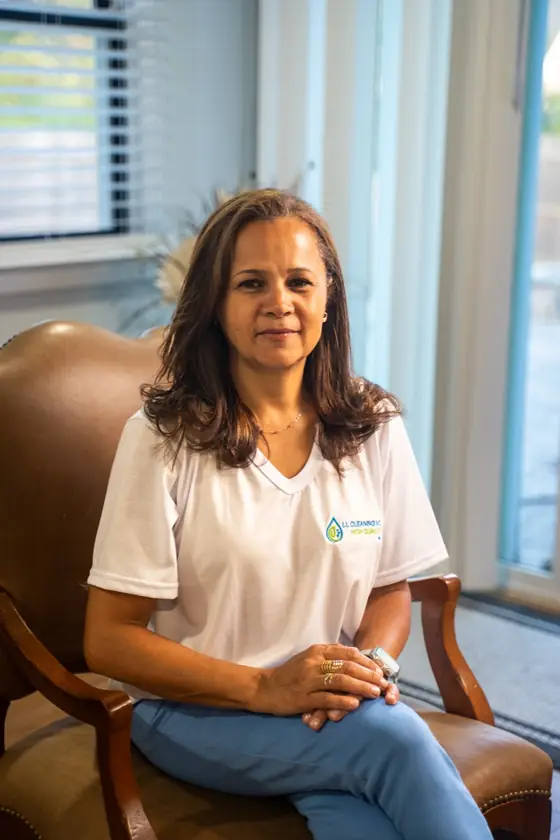 LL Cleaning team member seated in a leather chair, smiling