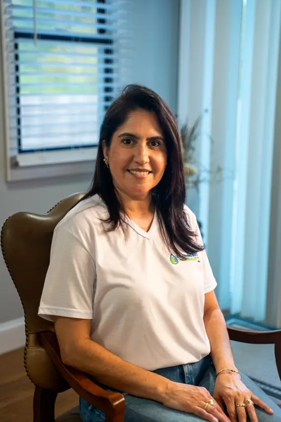 LL Cleaning team member seated in a leather chair, smiling