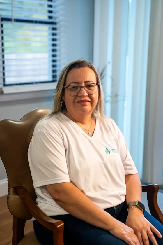 LL Cleaning team member seated in a leather chair, smiling