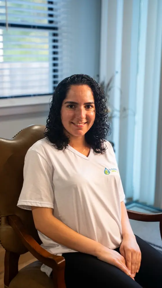 LL Cleaning team member seated in a leather chair, smiling