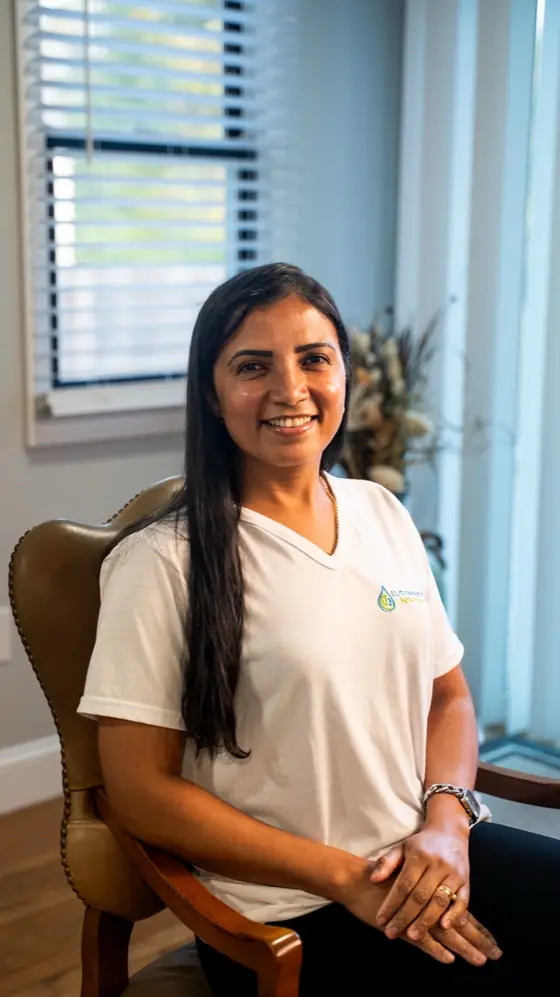 LL Cleaning team member seated in a leather chair, smiling